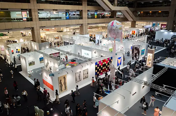 Vue du dessus d’un salon professionnel avec des stands et des participants